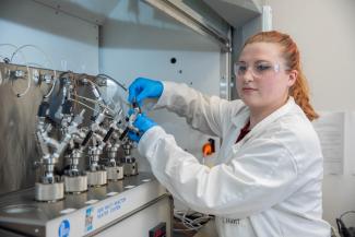 Student in front of chemical engineering equipment